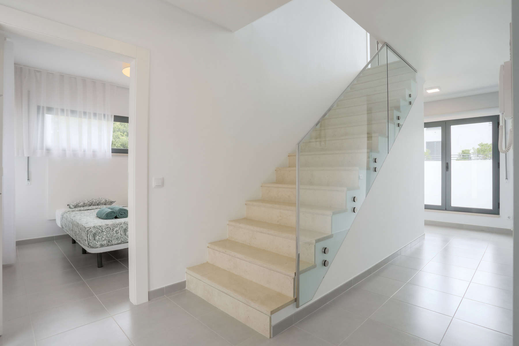 O hall principal dá acesso a um quarto com duas camas individuais, uma casa de banho, escadas para o primeiro andar e à sala de estar.
