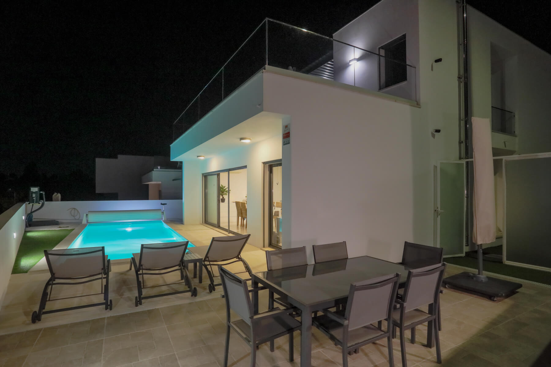 Desfrute do terraço com a sua cozinha ao ar livre à noite, enquanto os seus filhos brincam alegremente na piscina.